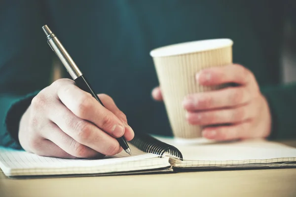 Händer med penna och kaffe — Stockfoto