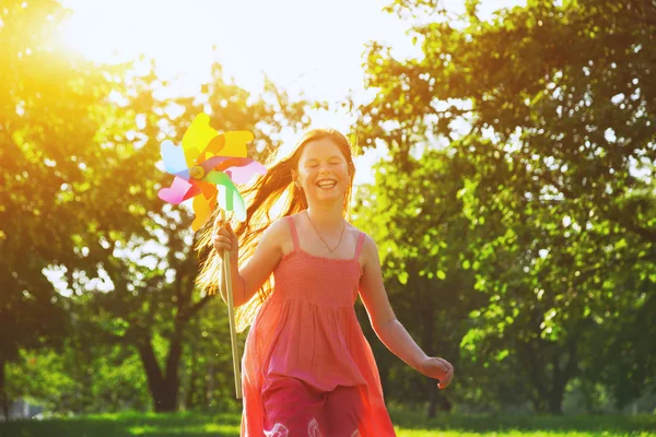 Menina feliz com brinquedo pinwheel — Fotografia de Stock