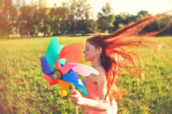 Chica pelirroja feliz con pinwheel juguete — Foto de Stock