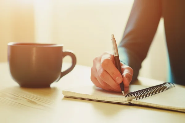 Hand met pen schrijven op notebook — Stockfoto