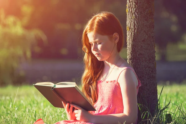 Μικρό κορίτσι κοκκινομάλλα ανάγνωση βιβλίων — Φωτογραφία Αρχείου