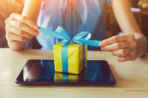 Hands with gift box and digital tablet — Stock Photo, Image