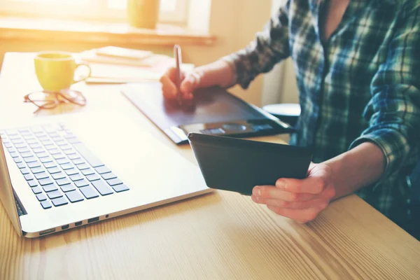 Diseñadores manos con la tableta y el ordenador portátil en la mesa —  Fotos de Stock