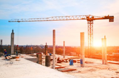 tower crane at construction site in morning sunlight clipart