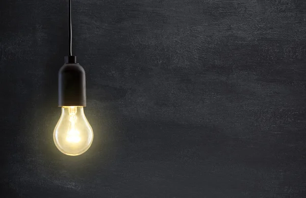 Glödlampa på svarta tavlan bakgrund med kopieringsutrymme — Stockfoto