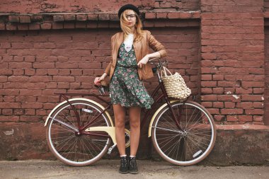 vintage bisiklet üzerinde tuğla duvar arka plan ile moda kadın