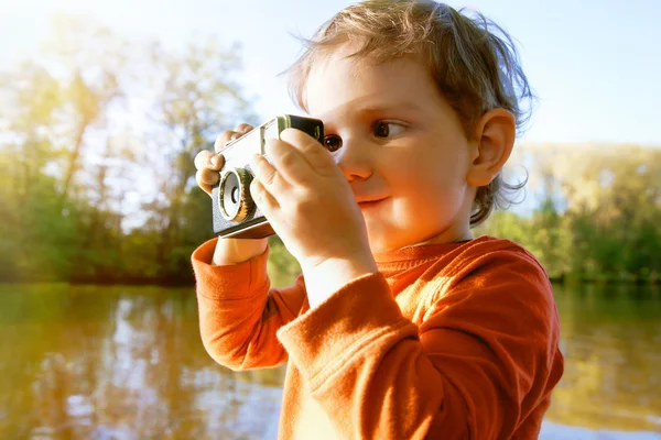 Portrét smějící se focením roztomilý chlapec s retro fotoaparát — Stock fotografie