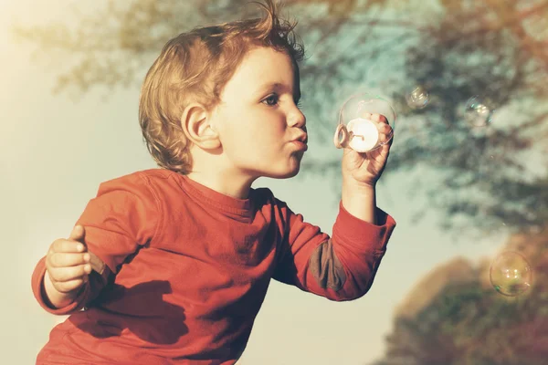 Piccolo ragazzo soffiando bolle di sapone — Foto Stock