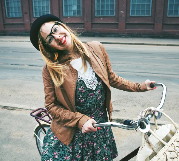 Веселая женщина с велосипедом на улице — стоковое фото