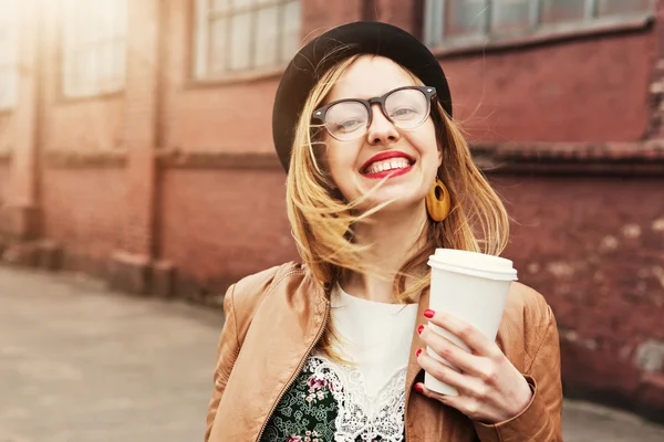 Mujer alegre en la calle bebiendo café de la mañana bajo el sol — Foto de Stock