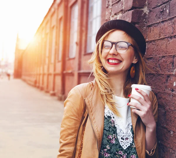 Mujer alegre en la calle bebiendo café de la mañana bajo el sol —  Fotos de Stock