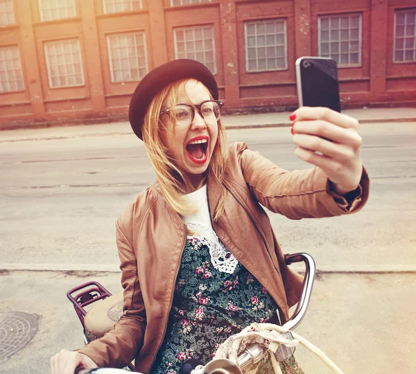 Estilo de vida da cidade menina hipster elegante com bicicleta usando um smartphone — Fotografia de Stock