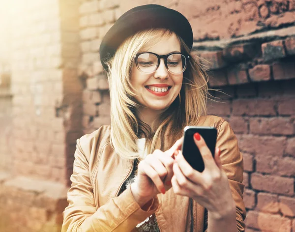 Estilo de vida de la ciudad chica hipster elegante usando un teléfono mensajes de texto en sma — Foto de Stock