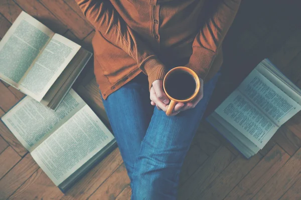 Girl having a break with cup of fresh coffee after reading books — Stock Photo, Image