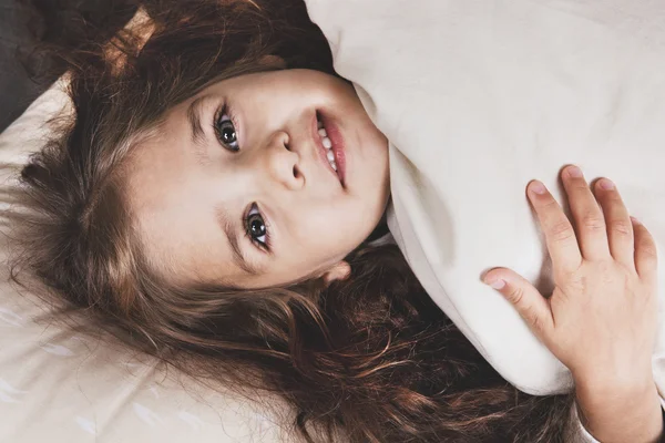 Hübsches kleines Mädchen liegt im Bett — Stockfoto