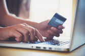 Hände mit Kreditkarte und Laptop. Online-Einkauf