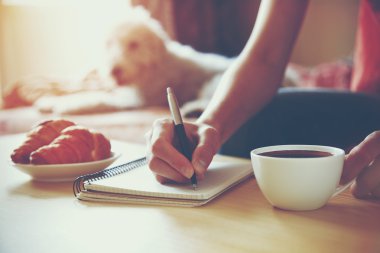 Eller üstünde defter sabah kahve ile yazma kalemi ile