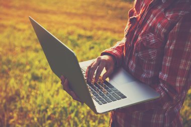 Dizüstü bilgisayar kullanarak ve dışarıda doğa zemin üzerine yazarak eller