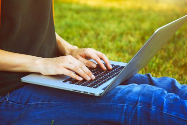 Dizüstü bilgisayar kullanarak ve dışarıda doğa zemin üzerine yazarak eller