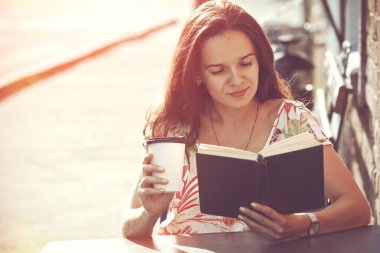 Gülümseyen kız sokakta yaz terası, kahve ile oturmak