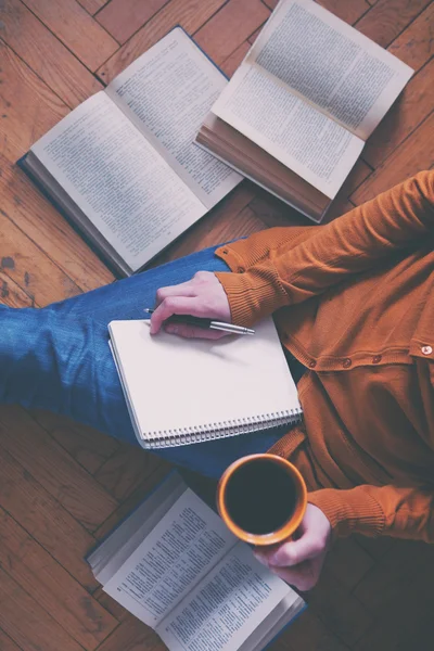 Girl having a break with cup of fresh coffee after reading books — Stock Photo, Image