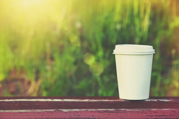 Xícara de papel de café no fundo natural da manhã — Fotografia de Stock