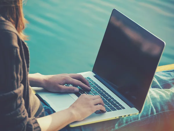 Flickorna händer som håller laptop i solljus — Stockfoto