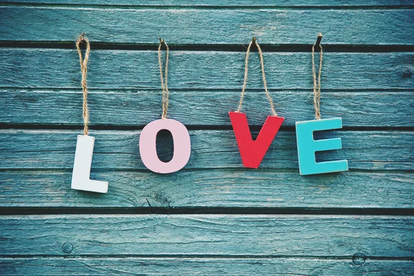 The word Love with wooden multi colored letters on natural board — Stock Photo, Image