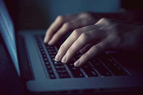 Manos con el ordenador portátil escribiendo en la noche — Foto de Stock