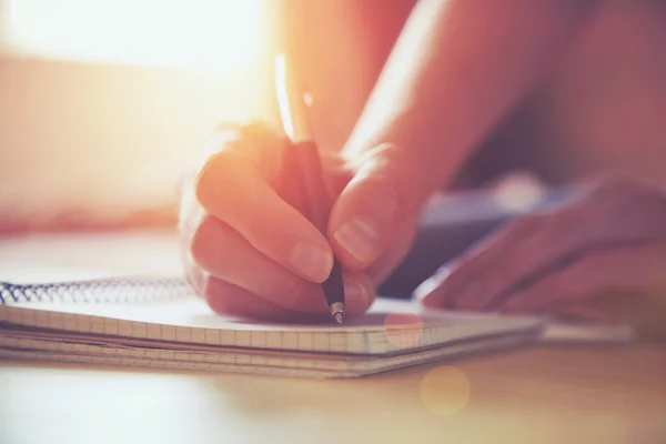 Mani femminili con scrittura a penna su taccuino — Foto Stock