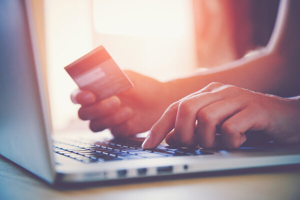 Manos sosteniendo la tarjeta de crédito y utilizando el ordenador portátil. Compras online — Foto de Stock