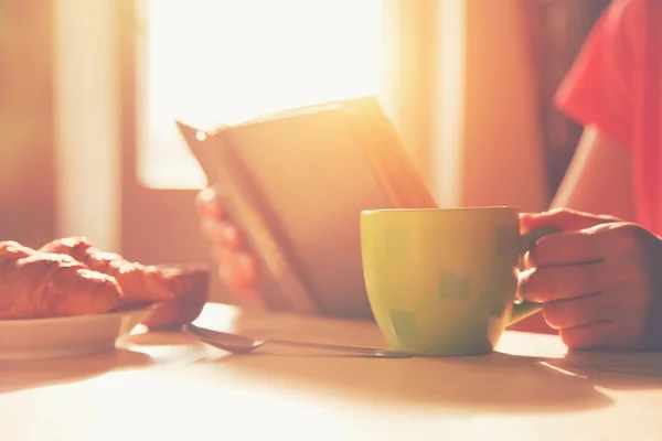Свіжий сніданок з гарячою кавою і читання книги вранці — стокове фото
