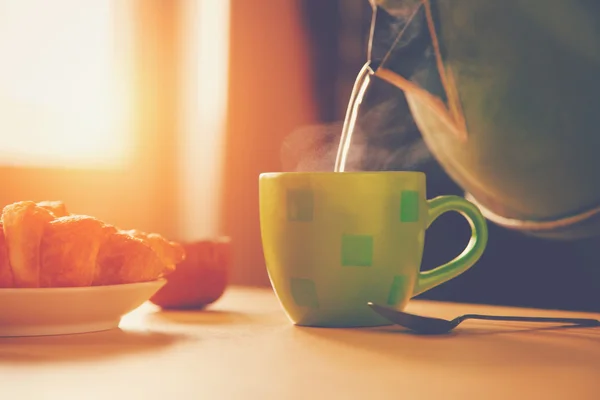 Hervidor de agua vertiendo agua hirviendo en una taza durante el desayuno — Foto de Stock