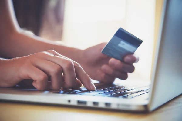 Manos sosteniendo la tarjeta de crédito y utilizando el ordenador portátil. Compras online —  Fotos de Stock