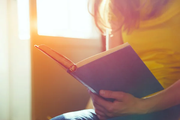 Mãos segurando livro e leitura à luz do sol — Fotografia de Stock