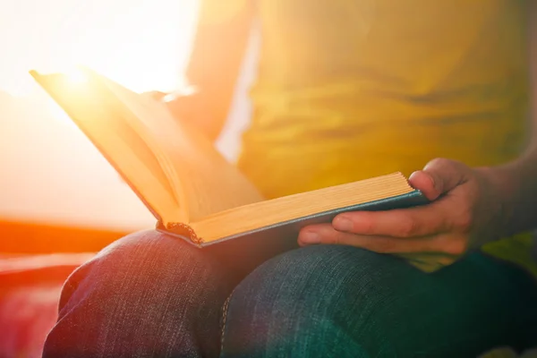 Handen houden boek en het lezen in zonlicht — Stockfoto