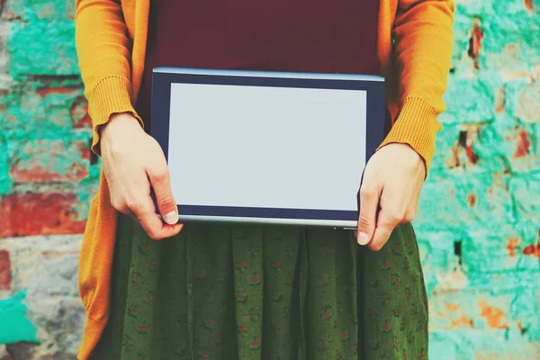 Mani in possesso di tablet PC digitale su parete di mattoni colorati — Foto Stock