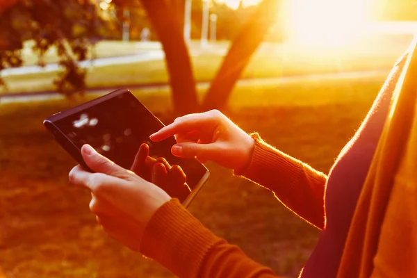 Hands holding digital tablet pc in summer sunset light — Stock Photo, Image