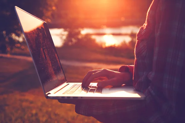 Ręce za pomocą laptopa i wpisując w wieczorem lub rano — Zdjęcie stockowe