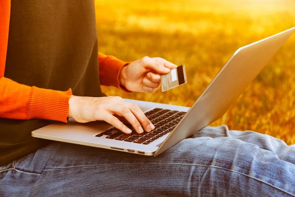 Mãos segurando cartão de crédito e usando laptop — Fotografia de Stock