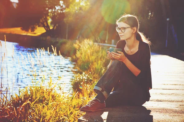 Lachende meisje met een kopje thee of koffie genieten op zomer kust — Stockfoto