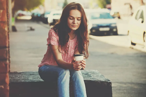 Chica bonita sentada en la calle con café de la mañana — Foto de Stock