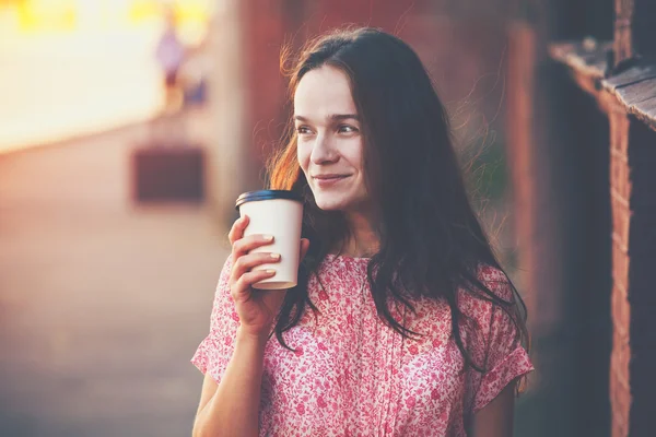 Smiling pretty girl walking in street with morning coffee — Stock Photo, Image