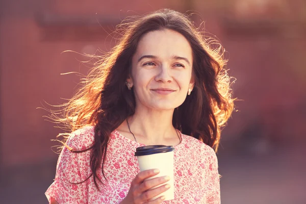 Smiling pretty girl walking in street with morning coffee — Stock Photo, Image