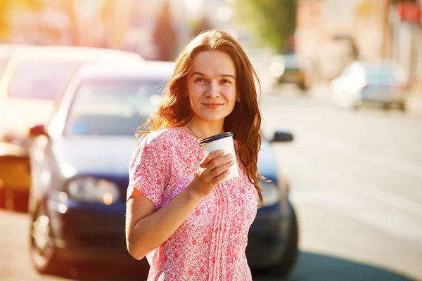 Tersenyum gadis cantik berjalan di jalan dengan kopi pagi — Stok Foto