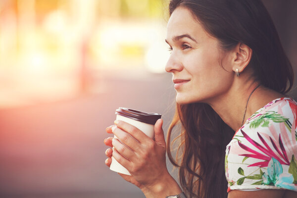 pretty girl sitting in street with morning coffee