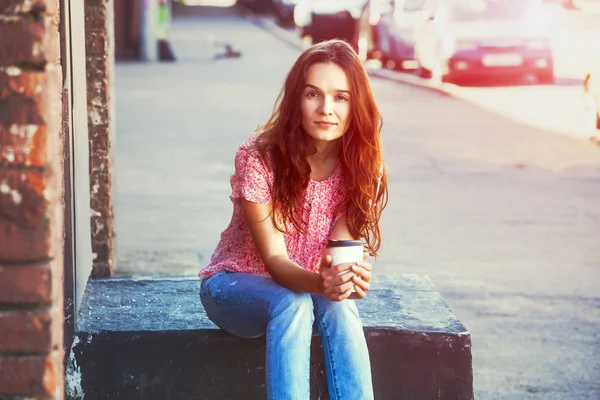 아침 커피를 마시며 거리에 앉아 있는 예쁜 소녀 — 스톡 사진