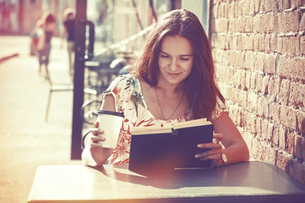 Ragazza seduta sulla terrazza estiva in strada con caffè del mattino — Foto Stock