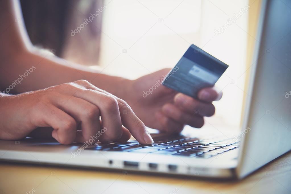 Hands holding credit card and using laptop. Online shopping