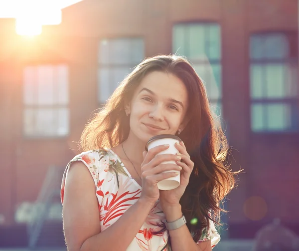 Lachende mooi meisje, wandelen in de straat met koffie in de ochtend — Stockfoto